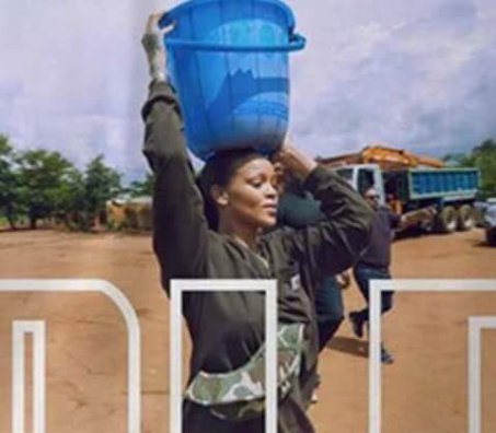 Rihanna pictured carrying a bucket of water on her head